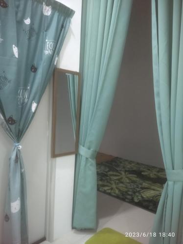 LunasRumah Lunas的一间设有蓝色窗帘和镜子的客房