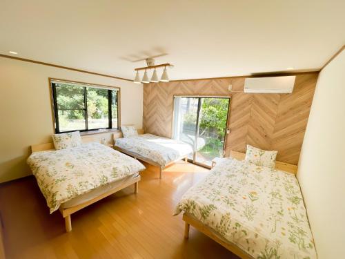 伊豆Izu Serenity Fuji-View Retreat with Private Onsen的带两张床和两个窗户的房间