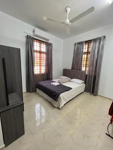 丹那美拉ROSSE HOMESTAY的一间卧室配有一张床和一台电视。