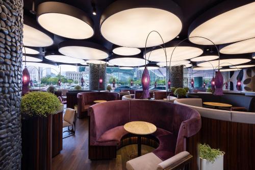 首尔首尔广场傲途格精选酒店的餐厅配有桌椅和灯光