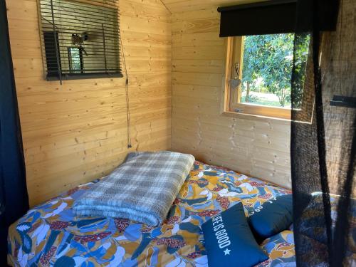 索利耶蓬Roulotte , hébergement atypique的小木屋内一间卧室,配有一张床