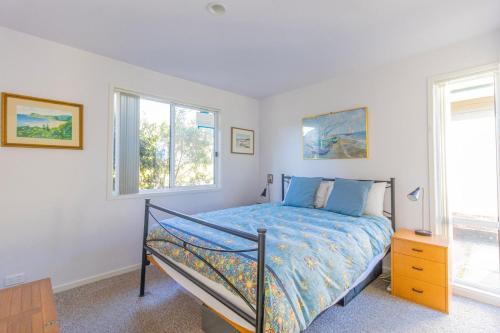 贝拉拉Kangaroo Cabin的一间卧室设有一张床和两个窗户。