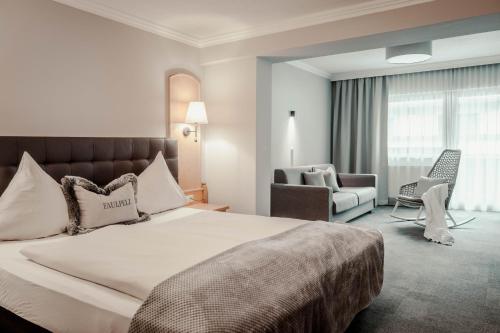 毛拉赫圣乔治湖景酒店的酒店客房带一张大床和一把椅子