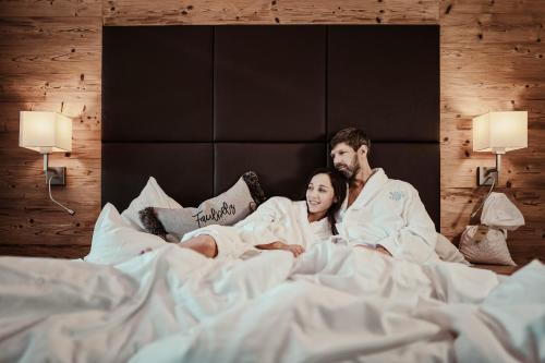 毛拉赫圣乔治湖景酒店的躺在床上的男人和女人