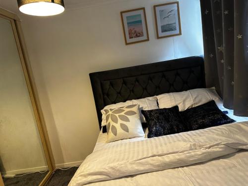 AddingtonLovely room in South London的一张带黑色床头板和枕头的床