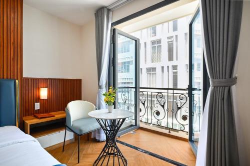 头顿PLUS VUNG TAU HOTEL的酒店客房设有带一张床和一张桌子的阳台。