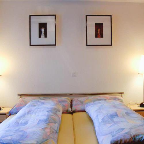 BözenGasthaus zum Bären的墙上有两张照片的房间的一张床位