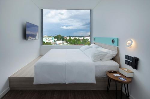 邦美蜀SOJO HOTEL DAK LAK的卧室设有白色的床和大窗户