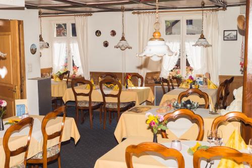 BözenGasthaus zum Bären的用餐室配有桌椅,鲜花盛开