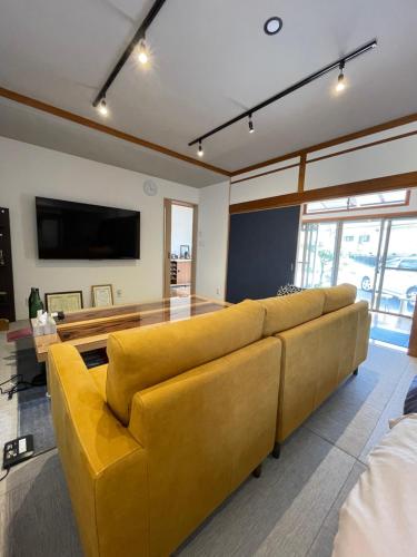 雾岛市Boss'sHouse犬ok天然温泉あり的客厅配有黄色的沙发和桌子