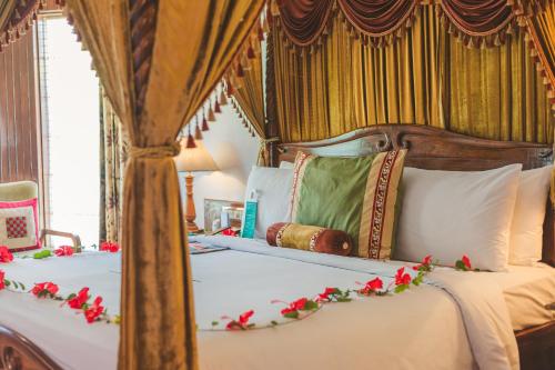 斋浦尔斋浦尔艾美度假Spa酒店的一间卧室配有一张带红色鲜花的天蓬床。