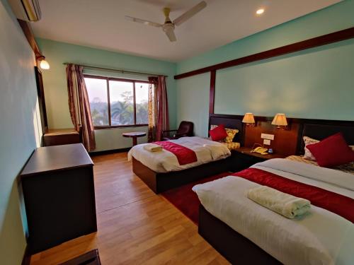 拉明德Hotel Ananda Inn的酒店客房设有两张床和窗户。