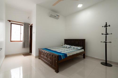 拜蒂克洛Sri Construction Circuit Bungalow的卧室配有一张床,墙上有十字架