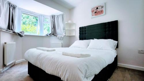 弗里姆利1 Bedroom Annex - Close to Frimley Hospital - Private Entrance的一间卧室配有一张大床和绿色床头板