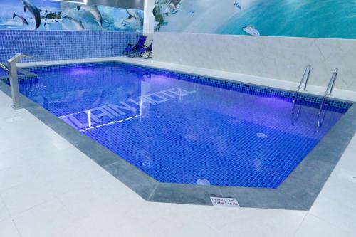 阿吉曼Alain Hotel Apartments Ajman的一座铺有蓝色瓷砖地板的大型游泳池