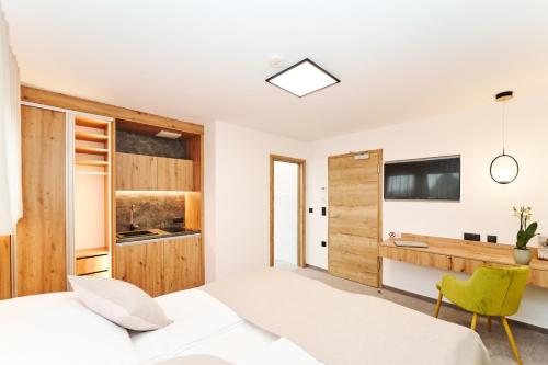 Feldkirchen bei GrazMedirooms Apartments的卧室配有白色的床和绿色椅子