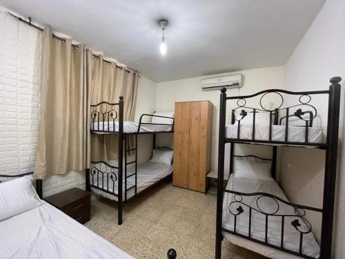 纳布卢斯YCC Guesthouse的一间小房间,配有两张双层床,另一间房间配有床