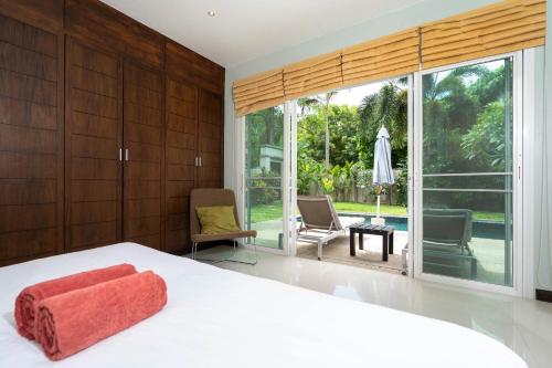 拉威海滩Balinese Style 3BR Villa Morning Forest, Nai Harn的卧室设有白色的床和大窗户