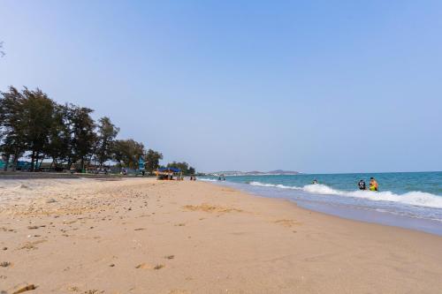 潘切TTC Hotel Phan Thiet的海滩上有人在水中散步