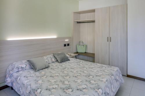 西尔米奥奈蒂利奥公寓别墅酒店的一间卧室配有一张大床和一个橱柜
