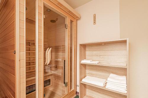诺瓦沃什Pool House Mržek Family Friendly - Happy Rentals的带淋浴、木制橱柜和毛巾的浴室