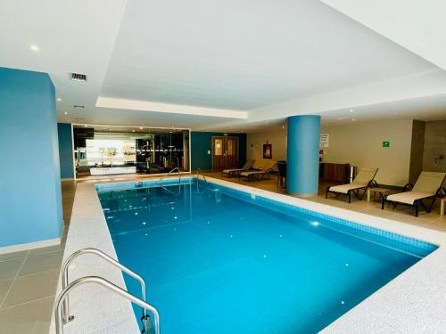 瓜达拉哈拉Holiday Inn Express - Guadalajara Vallarta Poniente, an IHG Hotel的蓝色柱子的酒店的大型游泳池