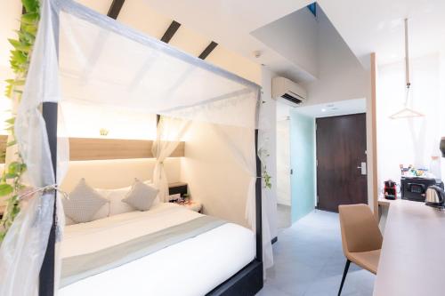 新加坡Hotel NuVe的一间卧室配有一张带天蓬的床