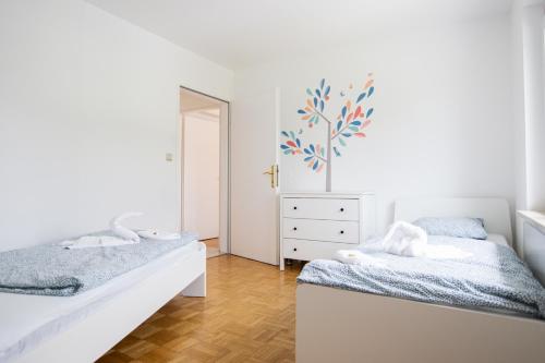 JormannsdorfLions Apartments - Erholung und Vergnügen in Bad Tatzmannsdorf的一间卧室配有两张床、一个梳妆台和镜子