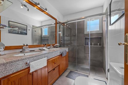 普拉亚布兰卡Villa Patos的一间带两个盥洗盆和淋浴的浴室