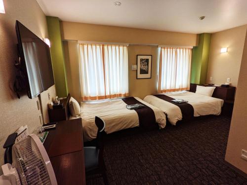 Matsuura阿米司塔特酒店的酒店客房设有两张床和一台平面电视。