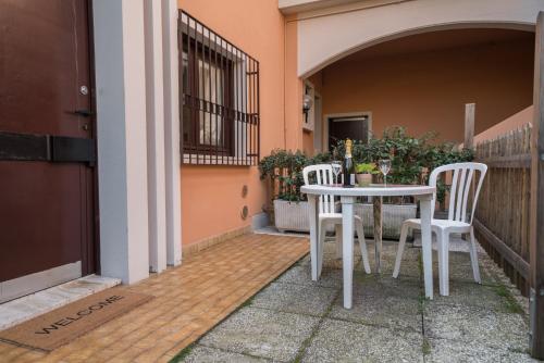 西尔米奥奈Gardappartamenti Sorgente Pool的庭院里设有两把白色的椅子和一张桌子