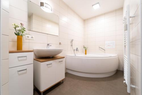 费尔德伯格Auerhuhn的白色的浴室设有浴缸和水槽。