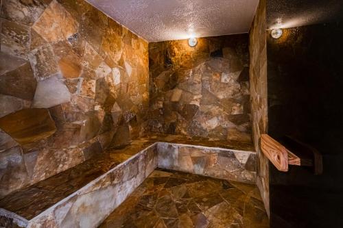 坎佩略Dormio Resort Costa Blanca Beach & Spa的一间带石墙和浴缸的浴室