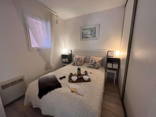 圣艾格夫Appartement Saint-Aygulf, 2 pièces, 4 personnes - FR-1-226A-88的一间卧室配有一张床,上面放着一个食物托盘