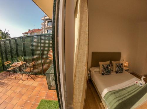 尼格兰CostaSerenaSuites的一间卧室设有一张床和一个美景阳台