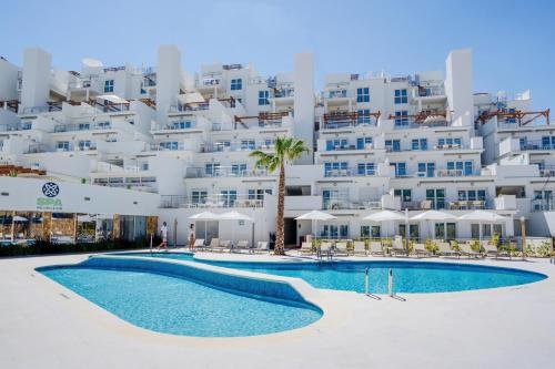 坎佩略Dormio Resort Costa Blanca Beach & Spa的大楼前设有游泳池的酒店