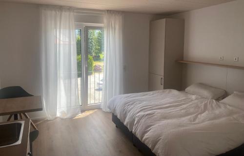 林道Obstbau Apartment am See的一间卧室设有一张床和一个大窗户