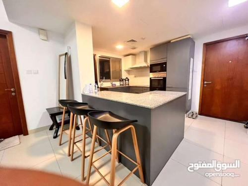 马斯喀特One Bed Room Apartment Muscat Hills的厨房配有吧台和酒吧凳