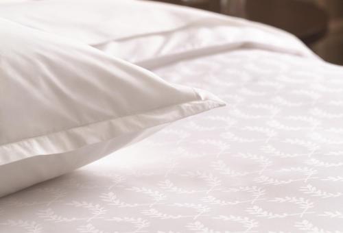 阿达纳大阿达纳喜来登酒店的白色的床、白色床单和枕头