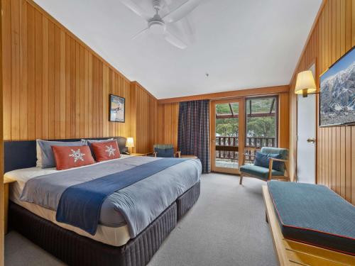 斯瑞德伯斯瑞德伯阿尔卑斯山酒店的一间卧室配有一张大床和一把椅子