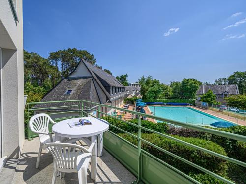 普雷斯科普Vacancéole - Ker Goh Lenn - Vannes / Morbihan的一个带桌椅的阳台和一个游泳池