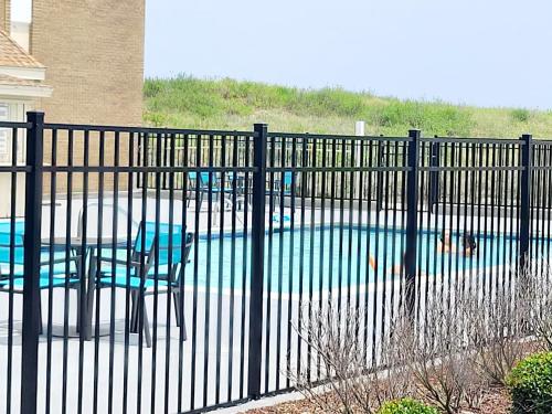 斩魔山Ocean Reef Suites的游泳池前带桌椅的围栏
