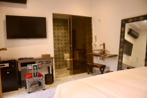 索维拉Riad Mellah的一间卧室配有一张床、镜子和电视