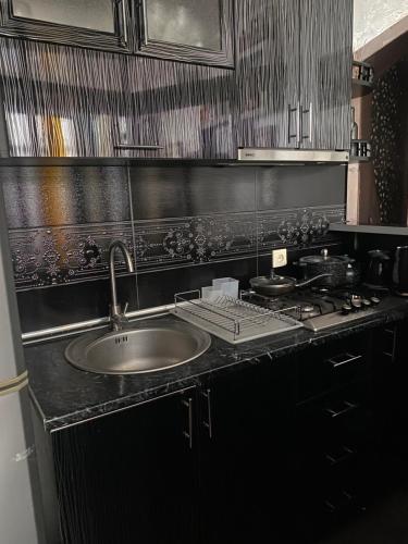巴统Dea Apartments的厨房柜台设有水槽和炉灶。