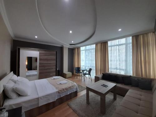 巴统Hotel Royal Palace的一间卧室配有一张床、一张沙发和一张桌子