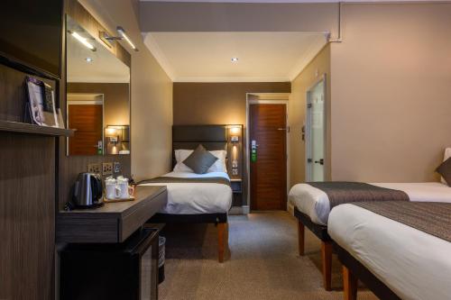伦敦布鲁奈尔酒店的酒店客房配有两张床和一张书桌