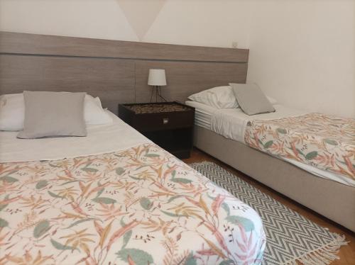 拉布Villas Arbia - Rio by the Beach的一间卧室配有两张床和一张带台灯的桌子