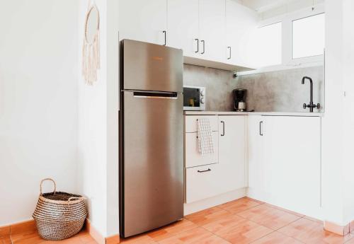 梅罗那瑞斯Apartamento Maypa 2 Salitre的一间厨房内的不锈钢冰箱,厨房内有白色的橱柜
