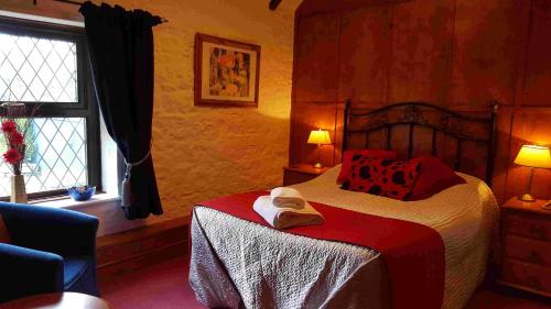 约维尔The Walnut Tree的一间卧室配有一张带红色枕头的床和一扇窗户