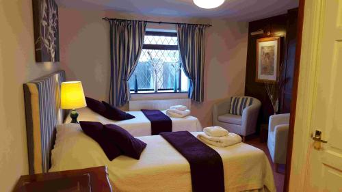约维尔The Walnut Tree的酒店客房设有两张床和窗户。